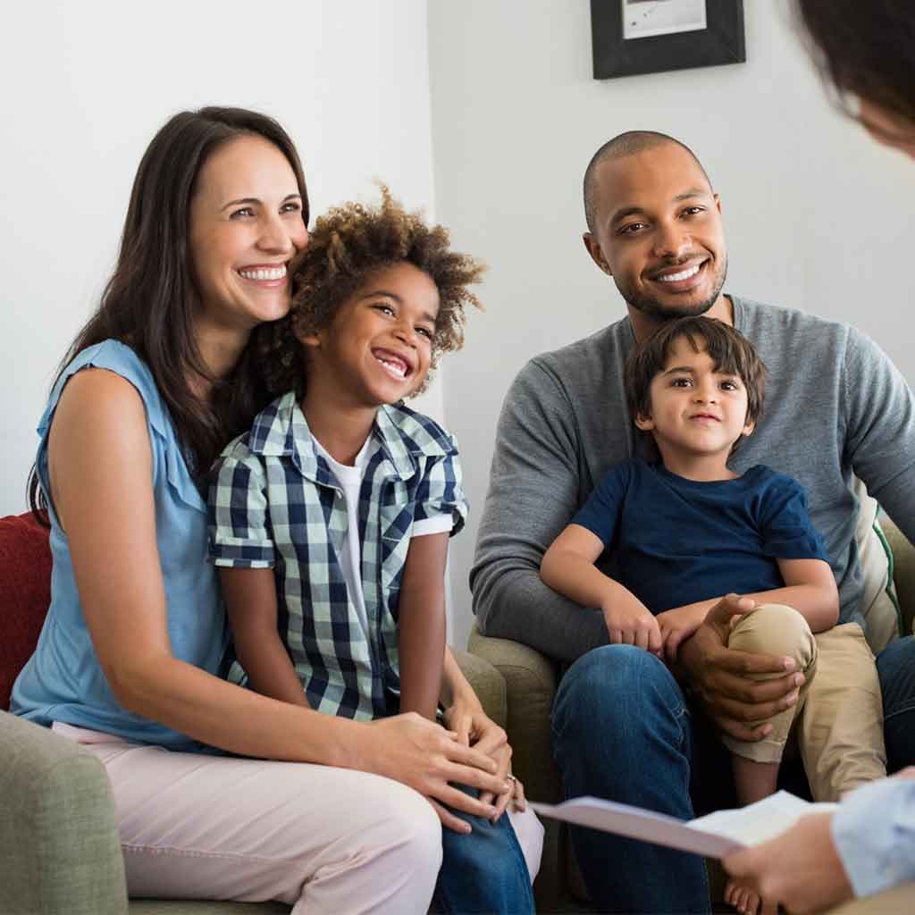 Family of four relaxing together at home
