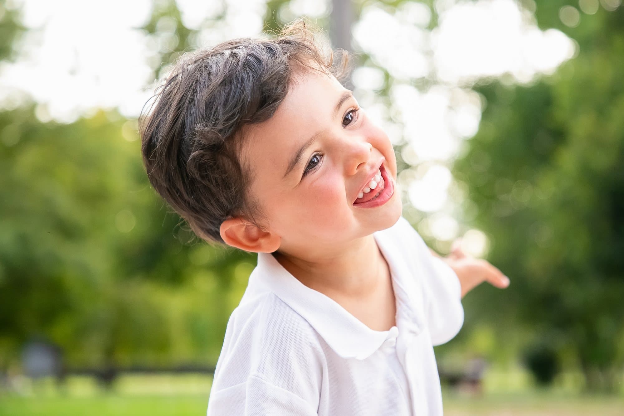 Happy young boy laughing outdoors