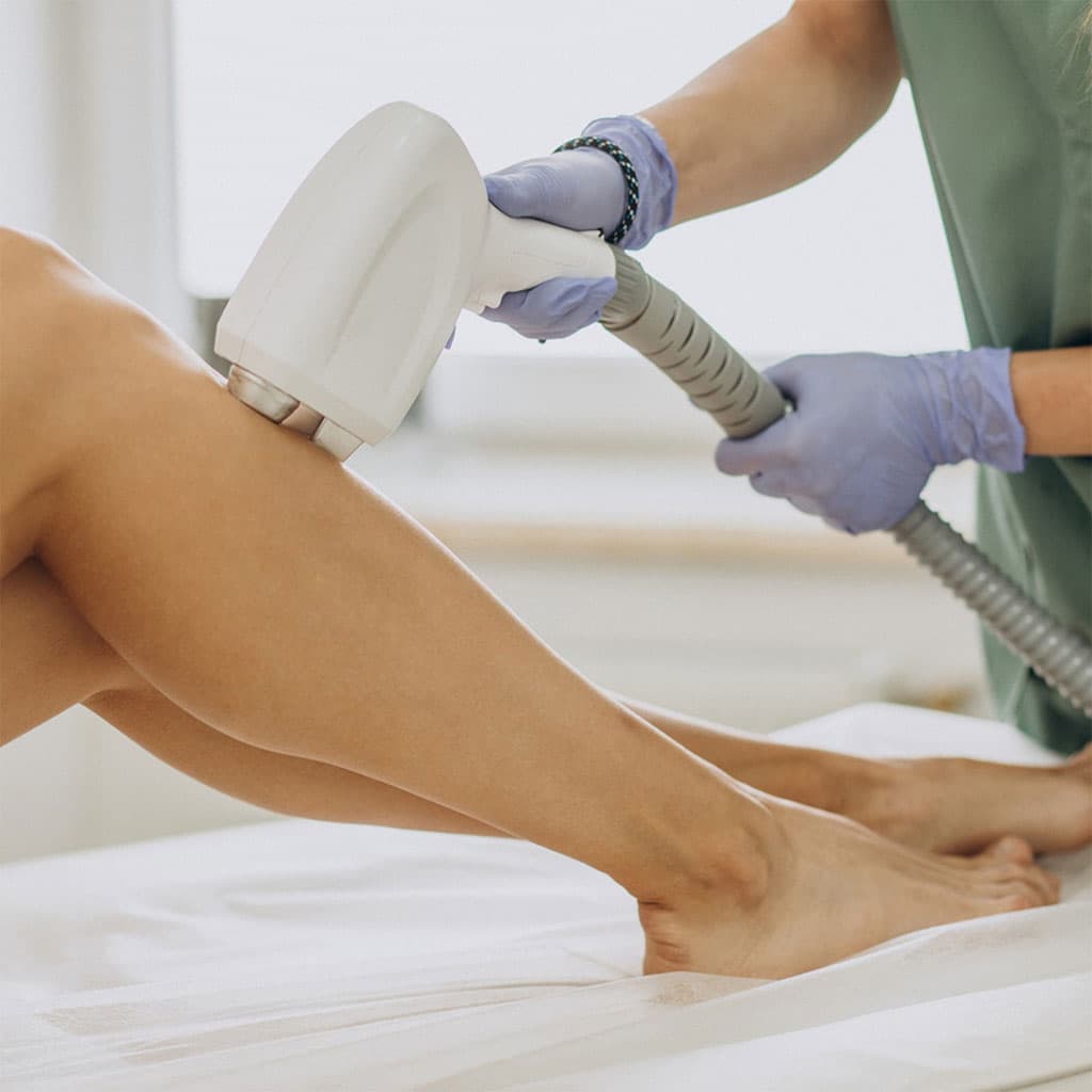 Clinician performing laser hair removal on a patient's legs
