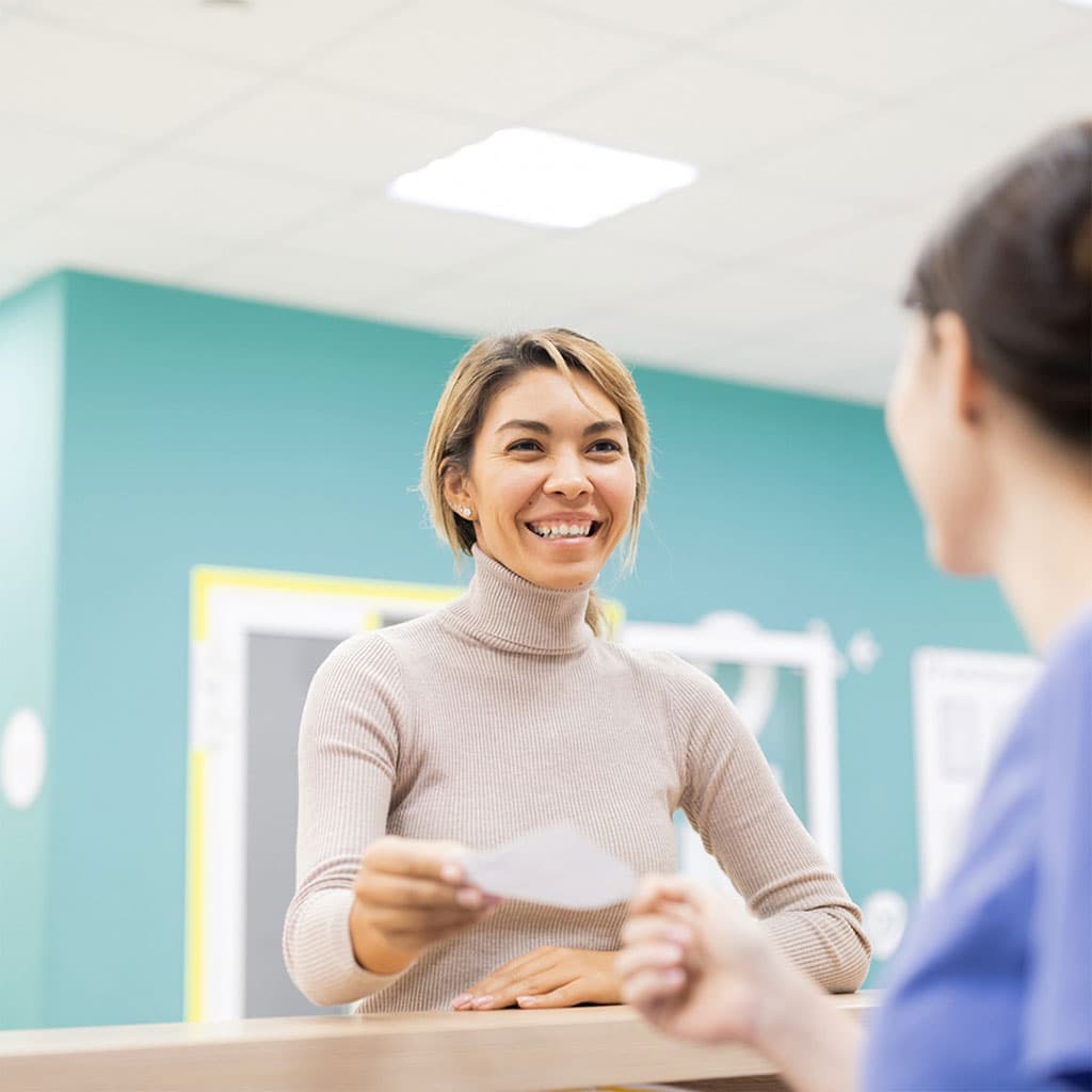 Patient smiling at the clinic reception desk